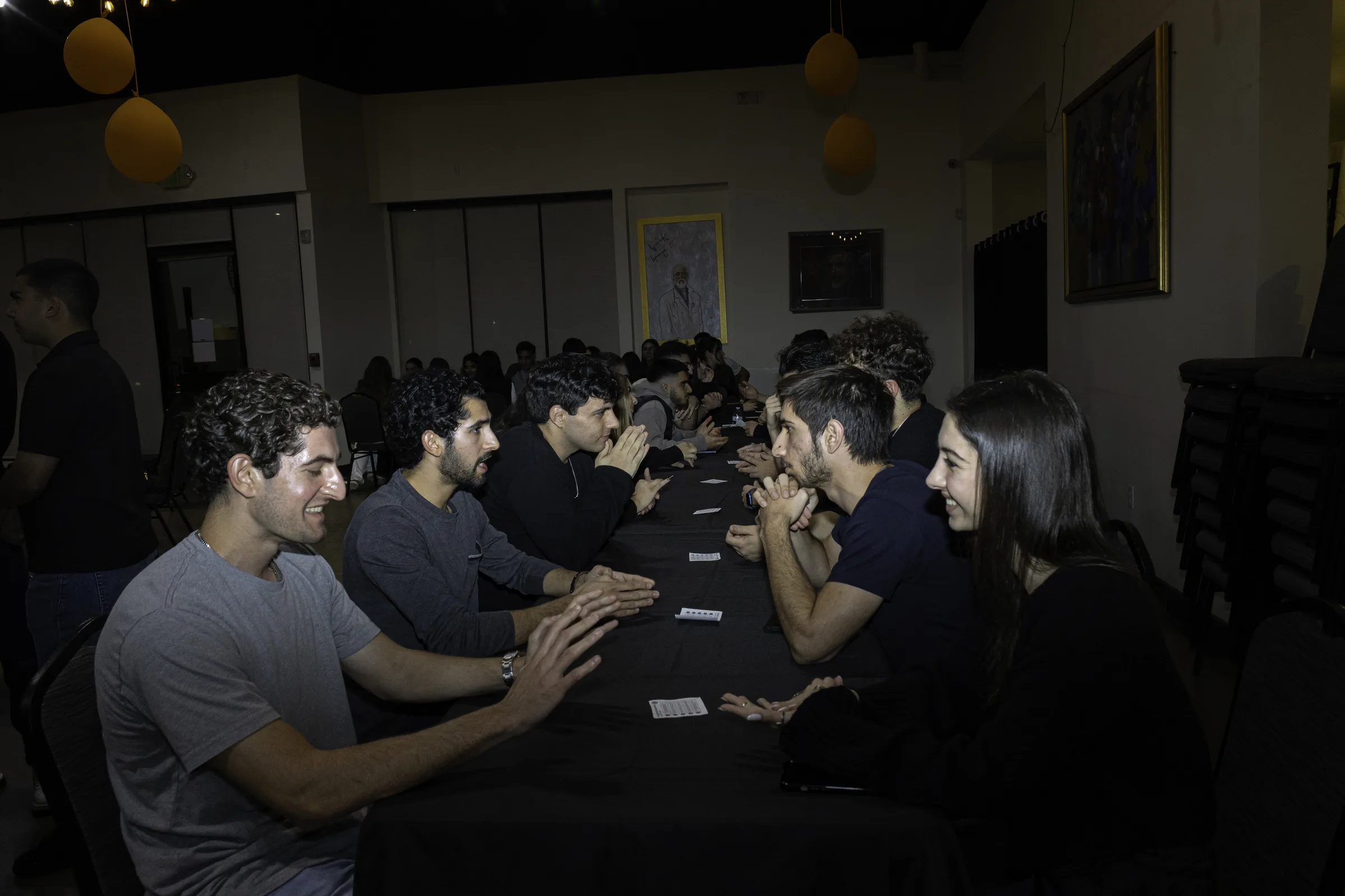 Attendees talking across a long table during speed networking.