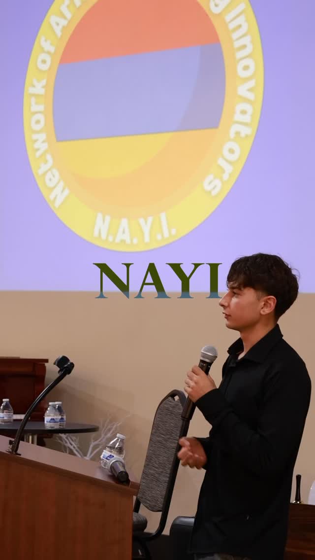 A NAYI speaker talking with attendees at the debut event.
