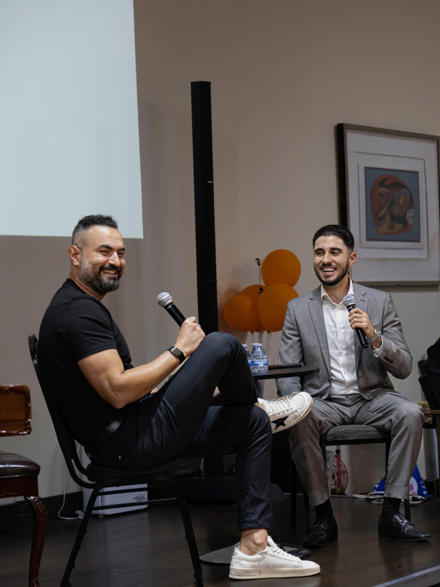 Two speakers laughing during a NAYI conversation.